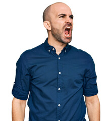 Canvas Print - Young hispanic man wearing casual clothes angry and mad screaming frustrated and furious, shouting with anger. rage and aggressive concept.