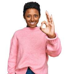 Wall Mural - Young african american woman wearing casual clothes smiling positive doing ok sign with hand and fingers. successful expression.