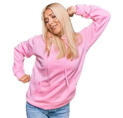 Wall Mural - Young blonde woman wearing casual sweatshirt stretching back, tired and relaxed, sleepy and yawning for early morning