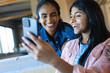 © Wavebreak Media - Smiling biracial teen daughter taking selfie with mother over smartphone at home, copy space