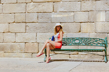 Beautiful Woman With Hat Sitting On A Bench