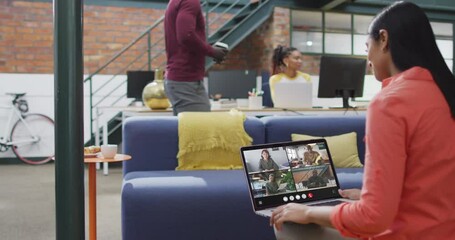 Sticker - Biracial woman using laptop for video call, with diverse business colleagues on screen