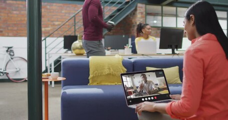 Sticker - Biracial woman using laptop for video call, with business colleague on screen