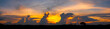 Panorama photo of Landscape sunset with dark clouds.Tree silhouetted against a setting sun.Dark tree on open field dramatic sunrise and vivid orange sky.