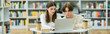 © LIGHTFIELD STUDIOS - teenage friends looking at laptop while studying in library reading room, banner.