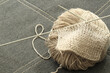 knitting needles and grey wool yarn ball
