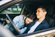 © stenkovlad - Young couple in a new car. A man driving a car with his girlfriend and having fun. Buying and renting a car. Travel, tourism, recreation.