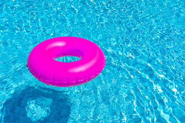 Wall Mural - Violet ring floating in blue swimming pool. Inflatable ring, rest concept