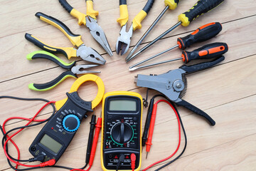 Electrical instruments, hardware tools for repair or maintenance, and installation of the electric system isolated on wooden background closeup.