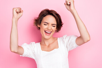 Photo portrait of adorable young girl raise fists lottery winner shouting yeah wear stylish white garment isolated on pink color background