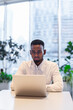 © Ranta Images - Portrait of young handsome stylish black man using laptop computer in coffee shop