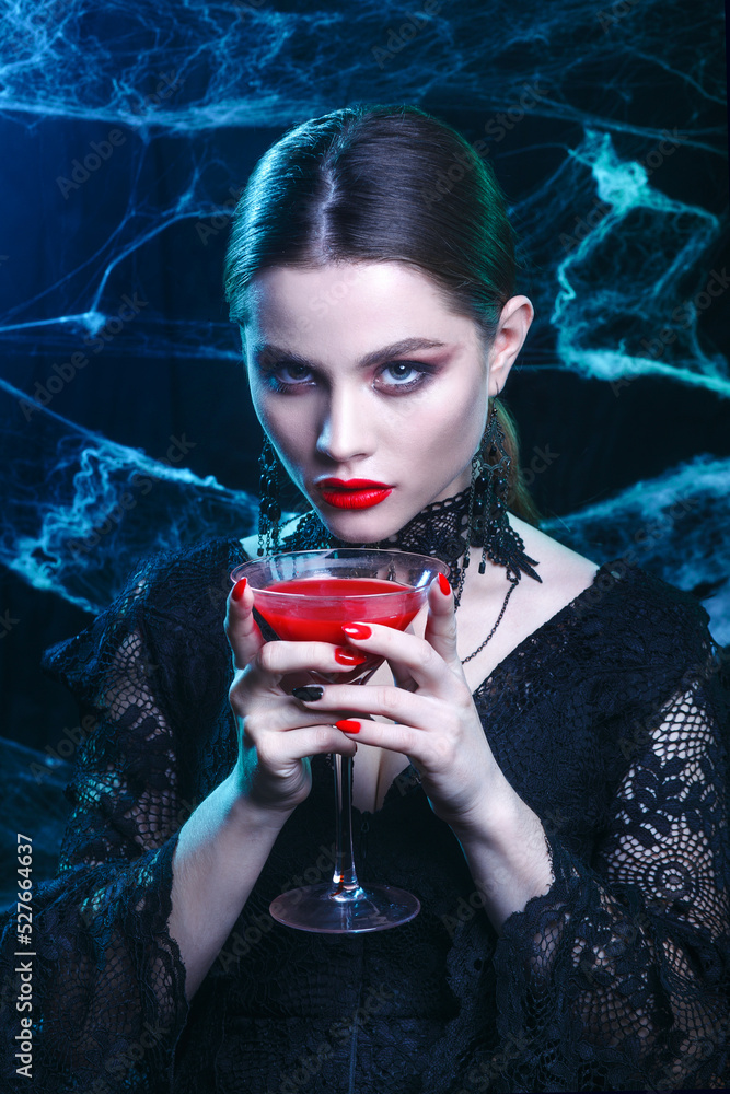 Halloween vampire woman portrait with a glass of wine on dark magic  background Stock Photo | Adobe Stock