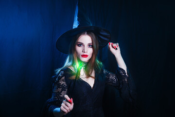 Beautiful witch with magic stick on dark background. Halloween witch concept