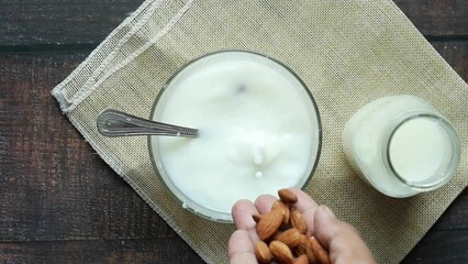 Wall Mural - slow motion of pouring almond nuts in a milk 