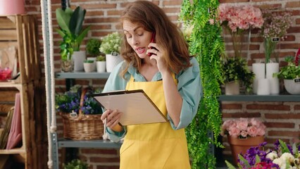 Sticker - Young beautiful hispanic woman florist talking on smartphone reading clipboard at florist