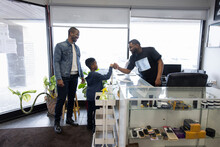 Barber And Boy Customer Fist Bumping At Barber Shop Front Desk