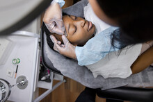 Esthetician Using Razor On Forehead Of Client In Beauty Salon