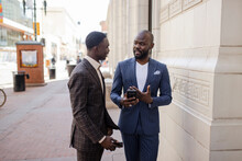 Stylish Businessmen In Suits Talking On City Sidewalk
