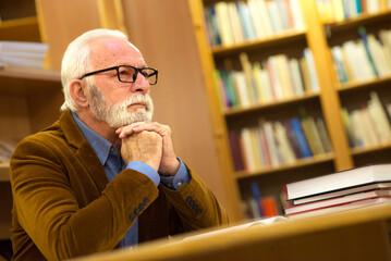 Wall Mural - Senior man reading book in the library