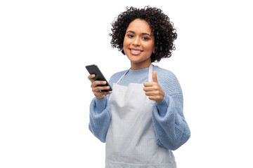 Wall Mural - cooking, culinary and people concept - happy smiling woman in apron with smartphone showing thumbs up over white background