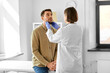 © Syda Productions - medicine, healthcare and people concept - female doctor checking lymph nodes of man patient at hospital