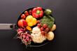 Directly above shot of various colorful vegetables in frying pan on black background