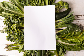 Wall Mural - Overhead view of fresh green vegetables on white table with copy space