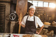 © Wavebreak Media - Portrait of smiling asian mid adult female baker with wooden oven spatula standing in bakery