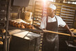 © Wavebreak Media - African american mid adult male baker keeping braided bread tray with long spatula in rack