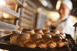 © Wavebreak Media - Asian mid adult female baker keeping baked braided bread tray in rack