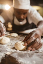 Close-up Of African American Mid Adult Male Baker Making Cross With Blade On Dough