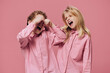 © Tatiana - a boy and a girl of school age in pink clothes stand on a pink background and fight fiercely with each other