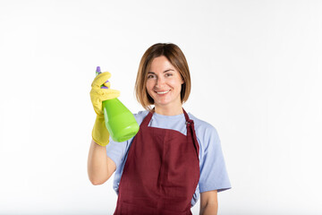 Attractive cheerful female contractor from cleaning service in red apron and violet rubber gloves holding cleaning tools isolated on white background