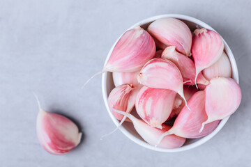 Wall Mural - Garlic. Fresh harvested organic garlic cloves bulb in bowl on gray stone background.