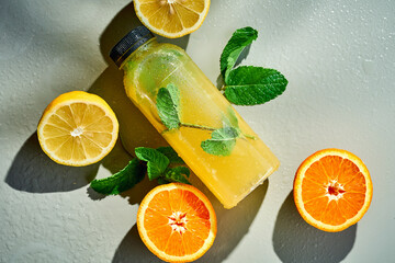 Wall Mural - Fresh lemonade in composition with orange and lemon. Gray background. Mocap. Hard light.