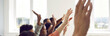 © Studio Romantic - Active multiracial audience raising hands. Happy mixed race multiethnic people sitting in row with hands up to ask coach questions after interesting talk, session, or master class. Header background