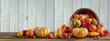 © TSViPhoto - Thanksgiving day background with empty copy space. Pumpkin harvest in wicker basket. Squash, orange vegetable autumn fruit, apples, and nuts on a wooden table. Halloween decoration fall design
