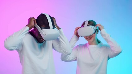 Poster - Happy diverse young people in white clothes put on vr helmet isolated over neon background