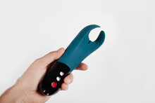 Man holding Silicone sex toys on a white background. Erotic toy for fun. Sex gadget and masturbation device..