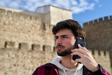 Serious Man Having Phone Call Near Old Building