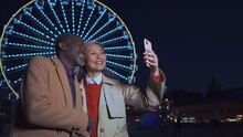 Happy multiethnic senior couple spending time together outdoor in the city. Asian wife and african husband sharing positive mood and happy moments