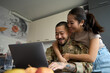 © Svitlana - Asian woman in kitchen room hugging from back of military