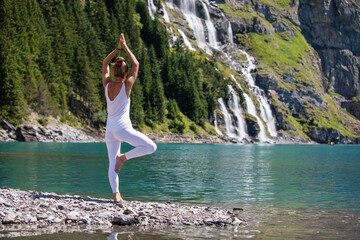 Wall Mural - A woman practices yoga in the mountains