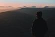 © Yurii Kushniruk - Man from behind standing and looking away at the mountains landscape in morning
