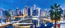 Marina With Yachts And Skyscrapers In Dubai UAE With Burj Khalifa At Night.