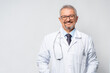 Horizontal Portrait of serious mature male doctor or therapist in white medical uniform, glasses and stethoscope, mature old man GP or physician in spectacles pose at white background healthcare