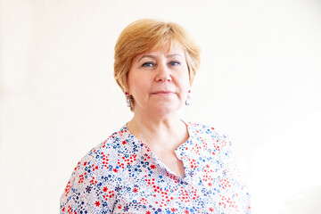 Portrait of 60-year-old woman on white background.