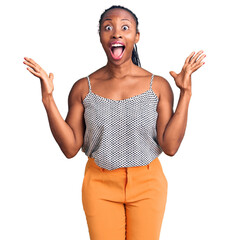 Canvas Print - Young african american woman wearing casual clothes celebrating crazy and amazed for success with arms raised and open eyes screaming excited. winner concept