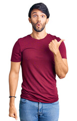 Poster - Handsome hispanic man wearing casual clothes surprised pointing with hand finger to the side, open mouth amazed expression.