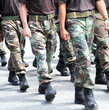 Soldiers in military uniform marching outside.